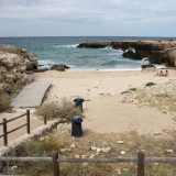 ...ma ci basta percorrere qualche passo per ritrovare finalmente la sabbia. Siamo a �Cala Monaci�, una spiaggia che si insinua fra due alti costoni rocciosi e alla quale � possibile accedere grazie a una passerella